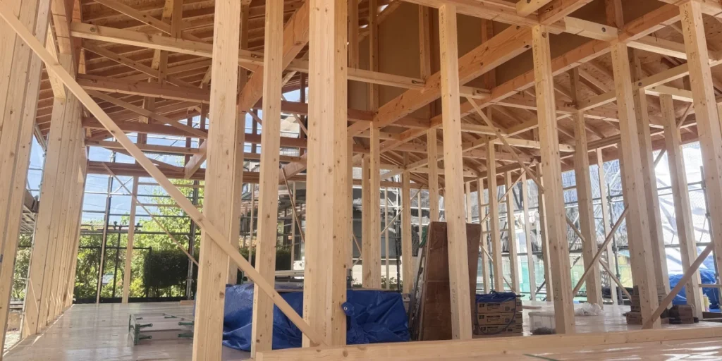 上棟を終え、柱や梁、屋根の骨組みが組み上がった住宅の内部の様子。