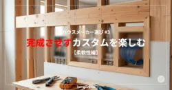 建築中の住宅の室内、壁の内部構造（木製の柱や下地）が露出している状態。配線用のブルーのケーブルが束ねられ、手前の木製作業台にはマルチメーター（測定器）やプライヤーなどの工具が並んでいる。「ハウスメーカー選び #3 完成させずカスタムを楽しむ【柔軟性編】」の文字タイトル入り。